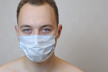 portrait of a young man in protective medical blue mask. self-isolation epidemic protection concept
