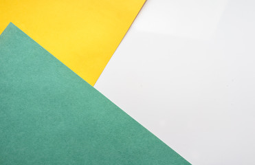 The composition of the colored sheets of paper. Geometric background. Bright typographic design  Top view, close-up 
