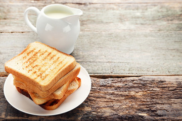 Toast bread with milk in jug on grey wooden table