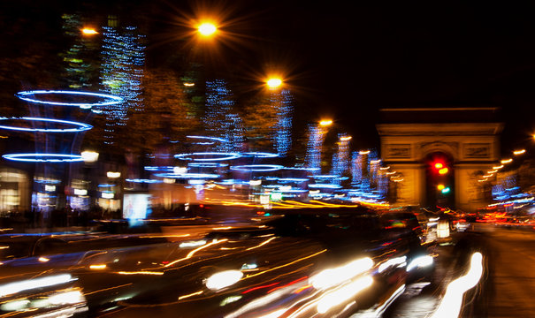 Paris. Blurred photo of Arch of Triumph and Champs Elysees with Christmas festive illumination. Blurry cars in motion. 