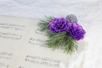 Christmas decoration with pine tree, red star and musical score on a white snow background