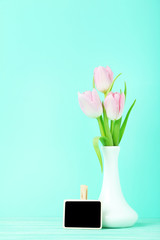 Bouquet of tulips in vase on green background