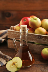 Apple vinegar in glass bottle on brown wooden table