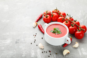 Fototapeta na wymiar Tomato soup with parsley on grey wooden table