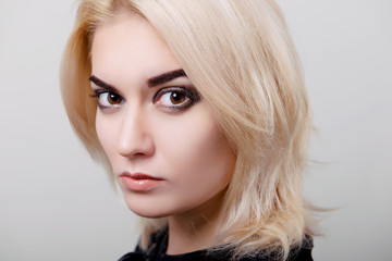 Fototapeta premium Blonde girl with bright makeup and clean skin on a white isolate close-up