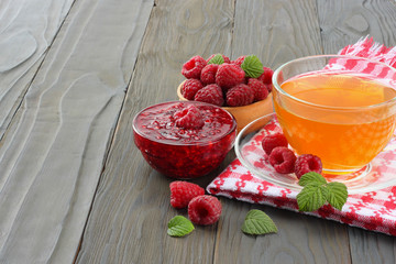 healthy background. raspberry with raspberry jam and tea on dark wooden background