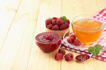 healthy background. raspberry with raspberry jam and tea on light wooden table