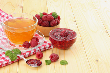 healthy background. raspberry with raspberry jam and tea on light wooden table