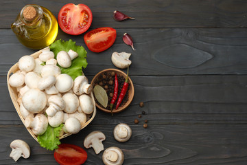 mushrooms with tomatoes, parsley, oil, garlic, chili pepper, peppercorns on dark wooden background. top view