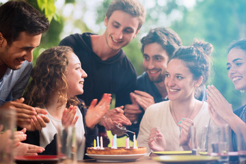 group of students celebrating a friend's birthday outside