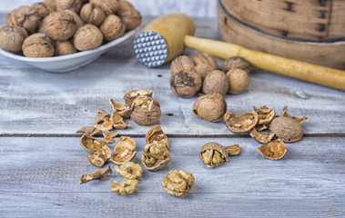 Walnut kernels and whole walnuts on the rustic grunge  table.