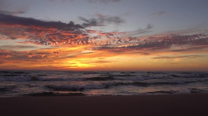 Waves washing ashore with beautiful sunset and clouds in the sky.