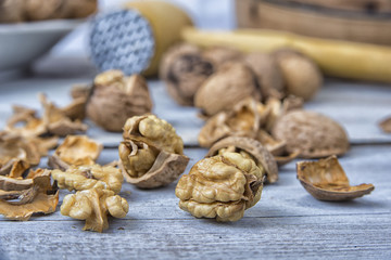Walnut kernels and whole walnuts on the rustic grunge  table.