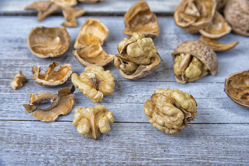 Walnut kernels and whole walnuts on the rustic grunge  table.