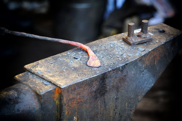 The blacksmith kicks a horseshoe