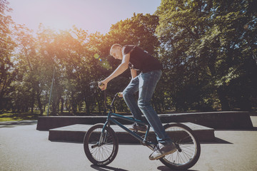 Bmx rider performing tricks at skatepark.