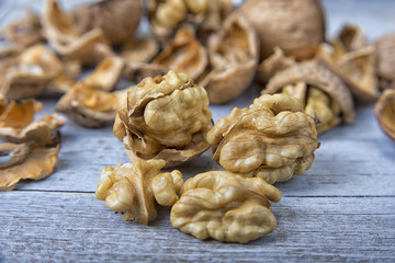Walnut kernels and whole walnuts on the rustic grunge  table.