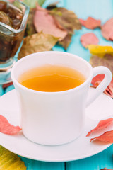 cup of tea on the table with fallen leaves