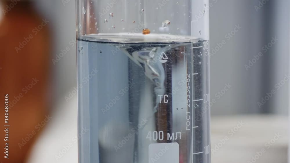 Aufkleber fluid changes color after mixing. close-up of colorful flask in which the liquid is mixed by a speci