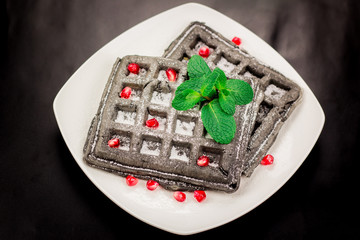 Black waffle with pomegranate