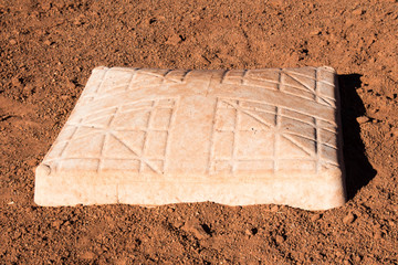 White baseball base in the dirt