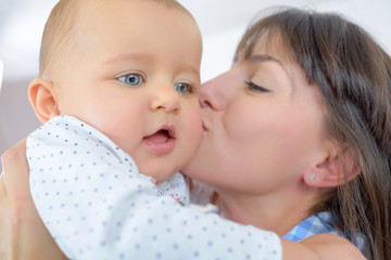 closeup of mother kissing baby