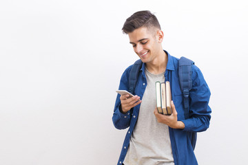 college adolescent student with books and mobile phone on wall background