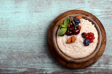 Fototapeta na wymiar Oatmeal with berries in bowl with place for text