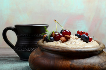 Oatmeal with berries in bowl with milk front view