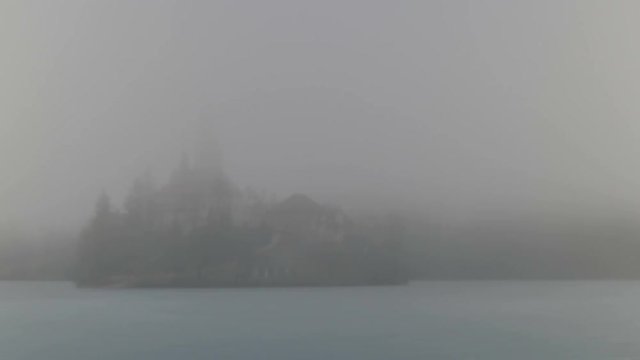 Bled Lake Island with Church in Winter Fog and Ice. Ultra HD 4K TimeLapse. Bled lake its castle and iconic island with church is a Slovenia iconic place with terme and hotel. Bled 5 February 2017.