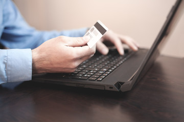 Man holding credit card and using laptop. Online payment and shopping