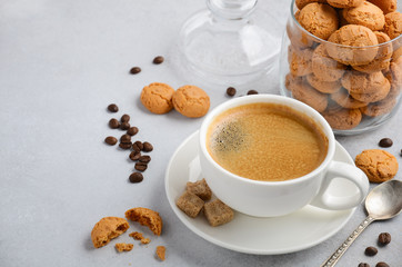 Cup of fresh coffee with Amaretti cookies on gray concrete or stone background, selective focus, copy space
