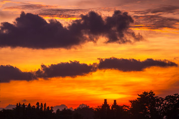 Abstract dramatic bright red yellow sky against a silhouette of a forest and a temple complex. Candi Prambanan Hindu Temple, Yogyakarta, Jawa, Indonesia.
