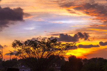 Abstract dramatic bright red yellow blue sky against a silhouette of a forest and a temple complex. Candi Prambanan Hindu Temple, Yogyakarta, Jawa, Indonesia.