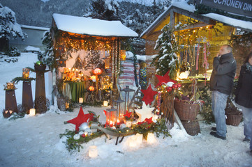 Weihnachtsmarkt in Bayern mit romantischen Holzbuden im Schnee