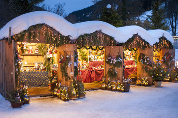 Weihnachtsmarkt in Bayern mit romantischen Holzbuden im Schnee