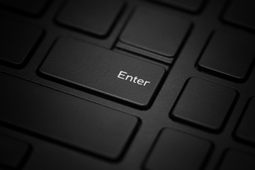 The enter key on a black laptop is close-up.
