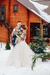 Obraz na płótnie Canvas Winter wedding outdoors on background of snow-covered house.