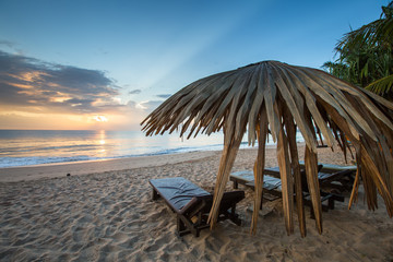 Sun loungers with umbrella on the beach, sunrise