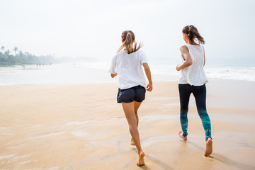 two women is jogging the seashore on an overcast day