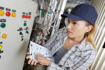 woman turning buttons of the machine in the factory