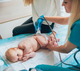 Doctor and little boy patient. Ultrasound equipment. Sonography. Hip dysplasia