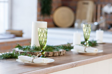 New Year and Christmas 2018. Festive kitchen in Christmas decorations. Candles, spruce branches, wooden stands, table laying.