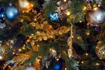 Obraz na płótnie Canvas gold Christmas toy in the form of a ball hanging on the tree