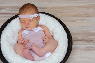Sweet newborn girl in basket sleep deep