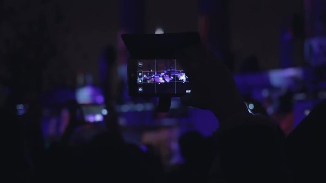 People shoots 3D mapping light show on a mobile phone.