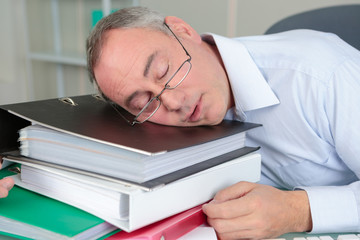 senior male accountant sleeping on the table