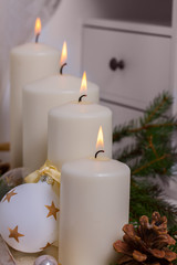 Four White burning advent candles with christmas decorations
