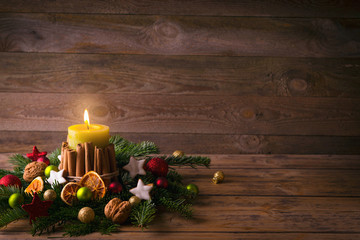 Christmas or advent background  -  Burning candle with natural decoration on rustic wood