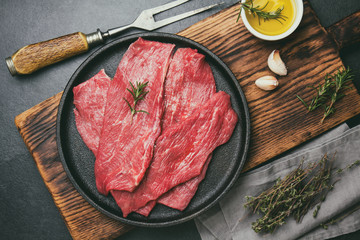 Raw meat beef on cast iron plate. toned, top view